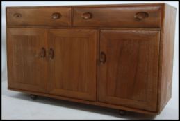 A retro Ercol 20th century windsor pattern golden dawn elm sideboard having a pair of drawers over
