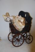 A 20th century Victorian style children's pram together with an assortment of dolls and teddies.
