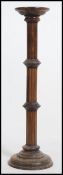 A 19th century Mahogany torchere plant stand standing on a circular base and a turned column.