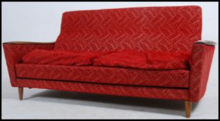 A 1960's Danish influence sofa day / bed raised on tapered legs having teak and original moquette
