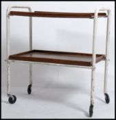 A vintage 1950's tubular metal and teak tray trolley having 2 tiers with painted white finished -