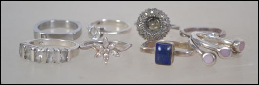 A collection of nine silver dress rings.