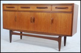 A 1970's G-Plan teak wood Fresco sideboard raised on shaped tapering legs having series of short