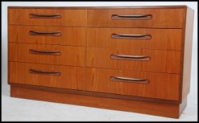 A 1970's G-Plan teak wood Kelso Pattern double chest of drawers being raised on an inset plinth