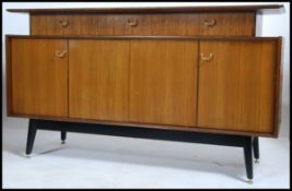 A 1960's G-Plan Librenza pattern teak wood sideboard raised on an ebonised plinth base with short