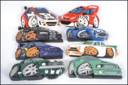 A collection of 7 hand carved and painted wooden wall plaques of vehicles to include Subaru,