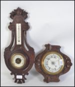 Two 20th century oak cased 1930's wall barometers each having carved frames