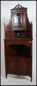 An Edwardian rosewood and marquetry inlaid corner cabinet being raised on shaped legs with cupboard