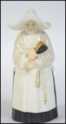 A royal Worcester candle snuffer in the form of a nun.