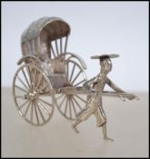 A sterling silver novelty figure group modelled as rickshaw with canopy and operator.