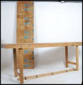 A pair of long mid century retro Industrial trestle tables of solid wood construction with planked