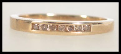 A hallmarked 9ct gold band ring with channel set chocolate diamonds. Size T. Weight 2.7g.