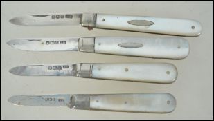 A Group of four Edwardian silver hallmarked mother of pearl handled fruit / pen knives.