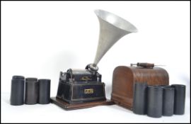 An early 20th century Edwardian Edison Gem phonograph being set upon a typical oak plinth complete