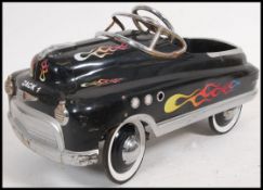 A 20th century 1950's style tin peddle car in the style of a hot rod in black painted finish