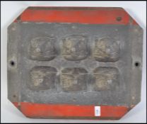 An unusual mid century Industrial heavy cast metal mould having metal mould of badgers heads set