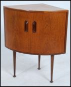 A retro 1970's G-Plan corner cabinet being raised on turned and tapering legs with pad feet.