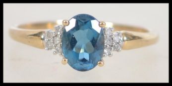 A 9ct gold blue topaz and diamond ring. Weight 2.1g. Size S.
