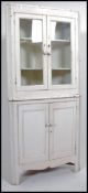 A 19th century Victorian white shabby chic painted pine glazed standing corner cabinet having twin