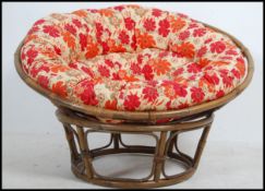 A retro 1970's bamboo pod chair having chintz upholstered large cushion on bamboo cage and base