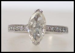 A ladies 18ct white gold and diamond marquise cut central stone ring having brilliant cut diamonds