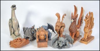 A collection of hand carved and painted wooden figurines to include griffin, dragons,