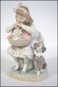 A Lladro figurine of a seated girl with a cream ruffled skirt holding a floral basket containing