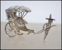 A sterling silver novelty figure group modelled as rickshaw with canopy and operator.