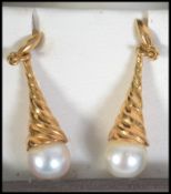 A pair of hallmarked 18ct gold and pearl earrings. Measures drop 1.5 inches. Hallmarked for London.
