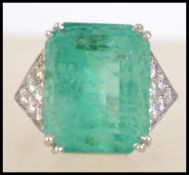 A platinum emerald and diamond ring.