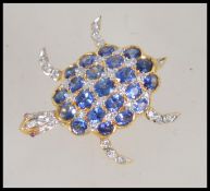 An 18ct gold sapphire diamond and ruby figural brooch pendant in the form of a turtle having