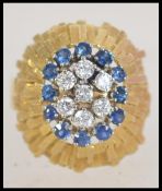 A 750 18ct gold sapphire diamond ring with central 5 stone diamond cluster with a blue sapphire