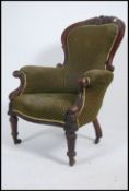 A Victorian mahogany spoon back armchair raised on reeded tapered legs with brown ceramic castors