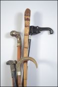 A collection of six early 20th century promenade canes to include one with an ebony shaft,