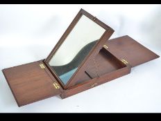 A 19th century campaign mirror with brass fittings fold out lid and later easel stand.