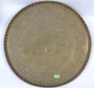 A large table top brass tray decorated i