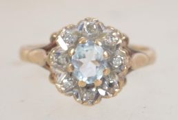 A hallmarked 9ct gold and diamond ring set with a central aquamarine surrounded by illusion set