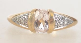 A hallmarked 9ct gold ring with central clear oval cut gemstone with illusion set diamond chip