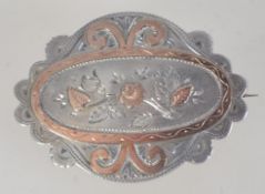 A hallmarked Victorian silver brooch, With chased floral and scroll decoration and c clasp.