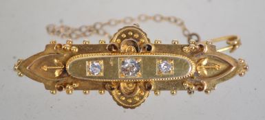A hallmarked 15ct gold and diamond Victorian bar brooch set with three diamonds,