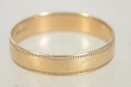 A hallmarked 9ct gold band ring with granulated decoration. Size R. Hallmarked for Birmingham.