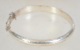A vintage hallmarked 925 silver bangle bracelet with foliate engraving.