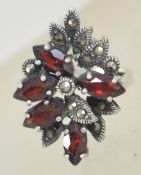 A silver 925 oversized ladies cluster dress ring set with marcasite and glass garnet stones.