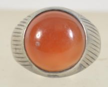 A silver white metal ladies dress ring with large round cut orange glass stone. Ring size U.