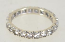 A 9ct gold eternity ring set with clear stones. Weight 2.4g. Size L. Marked 9ct tests 9ct gold.