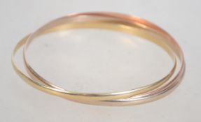 An Italian 9ct gold 3 coloured puzzle bangle. Stamped to inside A1 375. Tests 9ct gold.