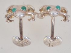 A pair of contemporary 925 silver figural cufflinks in the form of frogs with green gem eyes.