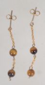 A pair of 9ct gold drop earrings with tigers eye beads post backs. Test 9ct gold. Measure 3cms.