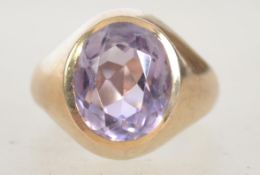 A hallmarked 9ct gold ring set with a large faceted amethyst stone in a bezel mount.