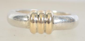 A 950 silver ladies dress ring with yellow metal ribbed centre.